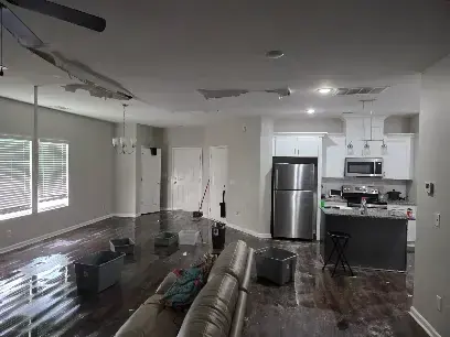 Kitchen and living room with water spread across the floor in Forest Hills, TN